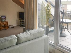 a living room with a couch in front of a window at Harbour Cottage in Millom