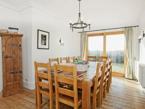 a dining room with a wooden table and chairs at Glan Y Mor 1 in Trearddur