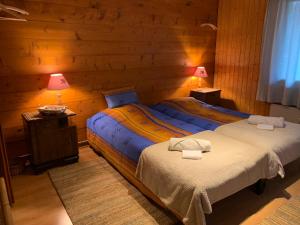 two beds in a room with wooden walls at La Cure de Vernamiège in Vernamiège