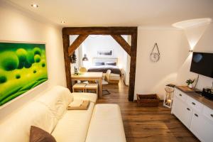 ein Wohnzimmer mit einem weißen Sofa und ein Schlafzimmer in der Unterkunft Altstadtjuwel @Conny's in Brilon