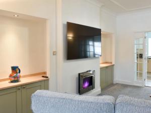 a living room with a couch and a tv on a wall at The Witheys in Woodhorn