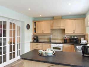 a kitchen with wooden cabinets and a black counter top at The Witheys in Woodhorn