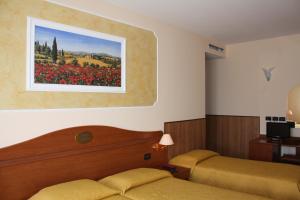 a bedroom with two beds and a painting on the wall at Hotel Belfiore in Salzano