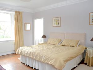 a white bedroom with a large bed and a window at Abbotts Farm in Horbling
