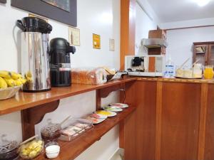 a kitchen with a shelf with food on it at Dreams House Cusco in Cusco