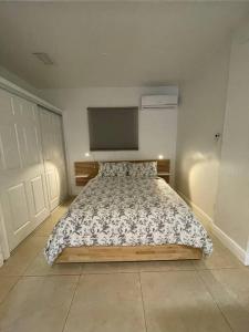 a bedroom with a bed and a flat screen tv at Comfortable modern apartment- central location. in Miami