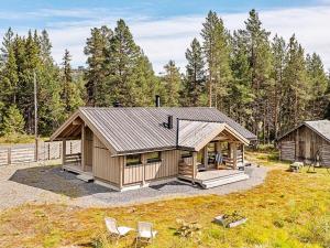 a cabin with a porch and chairs in a field at Holiday home Tisleidalen II in Tisleidalen