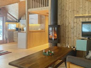 a living room with a table and a fireplace at Holiday home Tisleidalen II in Tisleidalen