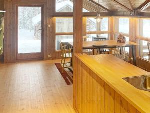 a room with wooden tables and chairs and windows at Holiday home Tisleidalen II in Tisleidalen