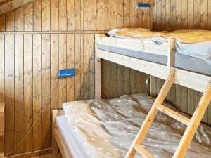 a room with two bunk beds in a wooden wall at Holiday home Tisleidalen II in Tisleidalen