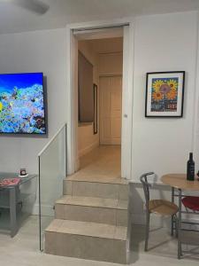 um corredor com uma escada, uma mesa e uma porta em Comfortable modern apartment- central location. em Miami