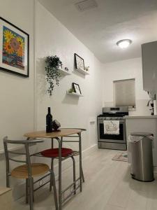 a kitchen with a table and two stools and a table with a wine bottle at Comfortable modern apartment- central location. in Miami