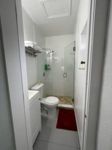 a white bathroom with a toilet and a shower at Comfortable modern apartment- central location. in Miami