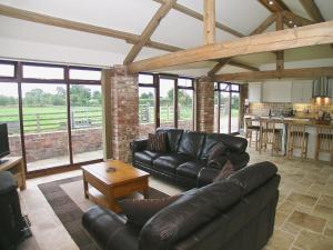a living room with leather couches and a table at Rising Sun Holiday Cottage in Aldwark
