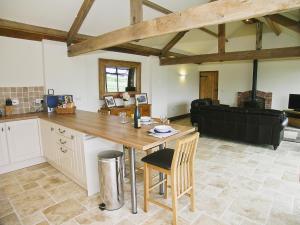 a kitchen and living room with a table and a couch at Rising Sun Holiday Cottage in Aldwark