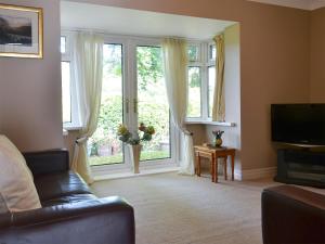 a living room with a couch and a large window at Bridge End Farm in Frosterley
