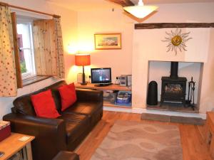 a living room with a couch and a fireplace at Foxhole in Threlkeld