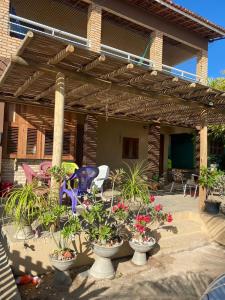 patio z doniczkami i drewnianą pergolą w obiekcie Chalés Sinfonia do Mar - Vista Paradisíaca w mieście Icapuí