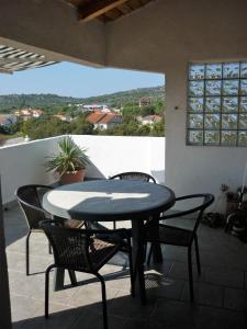 a table and chairs on a patio with a view at Apartmani Andrija in Jezera