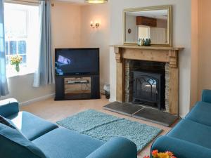 sala de estar con chimenea y TV en Meadow Cottage - 26912, en Saint Issey