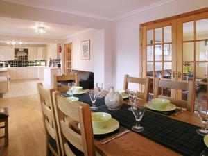 a kitchen and dining room with a table and chairs at Rowan Cottage in Carrbridge