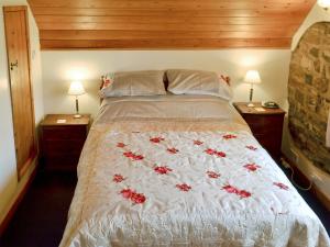 a bedroom with a bed with red flowers on it at The Garden House in Atlow