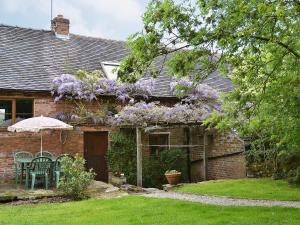 a house with purple flowers on the side of it at The Garden House in Atlow