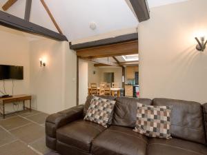 a living room with a brown leather couch and a table at The Old Forge in Kingston