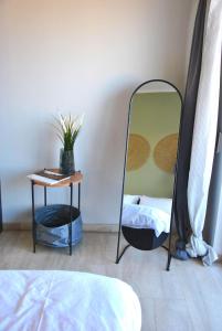 a mirror in a room with a table and a bed at Houseloft Meteora Spirit in Tríkala