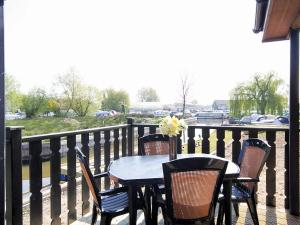 a table and chairs on a balcony with a view of a field at Nautical Nook in Stalham