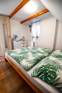 a bedroom with a bed with a green and white comforter at Chata73 in Nový Hrádek