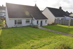 a white house with a large yard with a house at Atlantic Retreat - 5 minute stroll from the beach in Bude