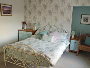 a bedroom with a bed with a floral bedspread at The Miners Cottage in Loftus