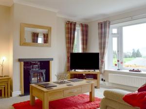 a living room with a tv and a coffee table at Brandelhow in Keswick