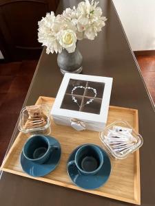 a table with a tray with plates and a picture and flowers at Accogliente appartamento a 25 minuti da milano in Parabiago +1 photo