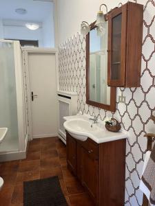 La salle de bains est pourvue d'un lavabo et d'un miroir. dans l'établissement Accogliente appartamento a 25 minuti da milano, à Parabiago
