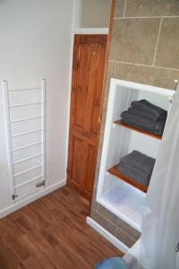 a bathroom with a closet with black towels on shelves at Atlantic Retreat - 5 minute stroll from the beach in Bude