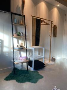 een kamer met een plank, een tafel en een spiegel bij La Fattoria Bed&breakfast in Venhuizen