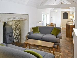 a living room with a couch and a wood stove at Seasong in Salthouse