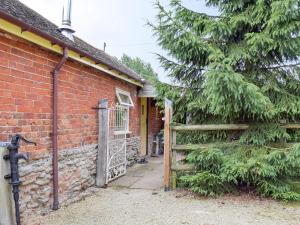 Rye Court Cottage في Birtsmorton: مدخل لبيت من الطوب مع بوابة خشبية