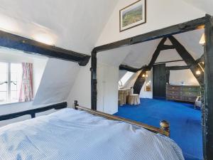a bedroom with a bed with a blue carpet at Glebe Cottage in Powick