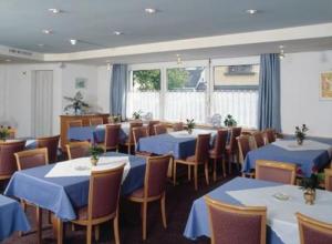 a dining room with blue tables and chairs at Hotel Sonne in Altstätten