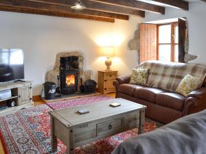 een woonkamer met een bank en een open haard bij Bruces Cottage in Saint Erth