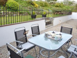 Bruces Cottage في Saint Erth: طاولة زرقاء وكراسي على الفناء