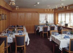 a dining room with white tables and chairs with blue napkins at Hotel Sonne in Altstätten +24 photos