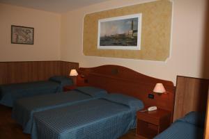 a hotel room with two beds and a picture on the wall at Hotel Belfiore in Salzano