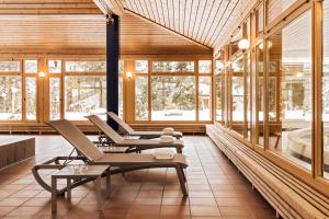 a room with chairs and a tub and windows at Faern Arosa Altein in Arosa