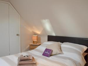 um quarto com uma cama branca e toalhas em The Nook em Westfield