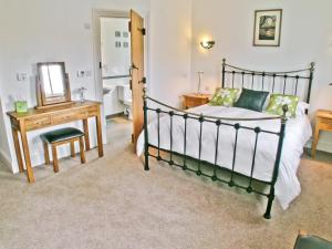 a bedroom with a bed and a desk and a mirror at Swallows Nest in Soulby