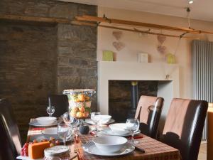 een eettafel met glazen en borden erop bij Garden Cottage in Weem